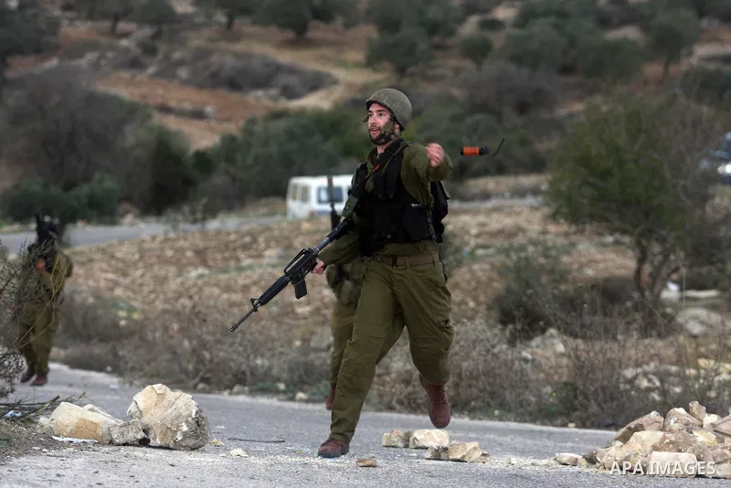 An Israeli soldier throw a tear gas canister during minor clashes against Israel's military operation in the Gaza Strip, in the West Bank village of Birzeit, near Ramallah November 19, 2012. Israel bombed dozens of targe...