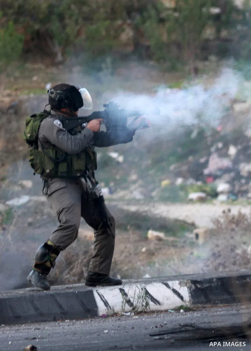 An Israeli soldier fires tear gas at Palestinian protester during clashes against Israel's military operation in the Gaza Strip, in the West Bank city of Nablus on November 19, 2012. Israeli air strikes killed 22 Palesti...