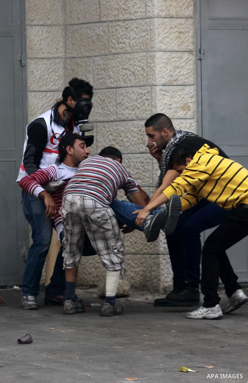 Palestinians carry a wounded man during clashes against Israel's military operation in the Gaza Strip, in the West Bank city of Nablus on November 19, 2012. Israeli air strikes killed 22 Palestinians, hiking the Gaza dea...