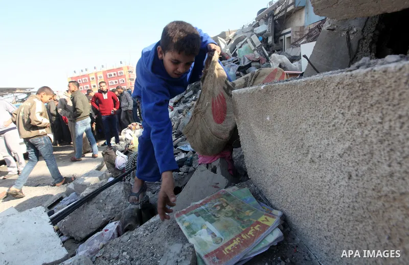 A Palestinian boy salvages his books from a building destroyed by an Israeli airstrike, in Gaza City, Gaza Strip, 20 November 2012. Media reports that Israel pounded more than 100 targets in Gaza on the seventh day of it...