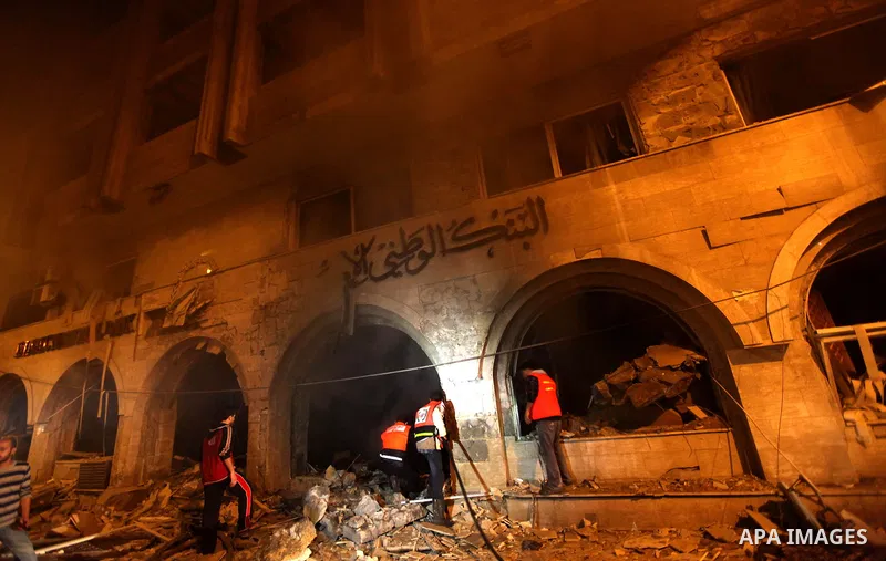 Palestinian firefighters try to extinguish a blaze after an Israeli air strike on the Islamic National Bank building in Gaza City on November 20, 2012. Israeli leaders discussed an Egyptian plan for a truce with Gaza's r...