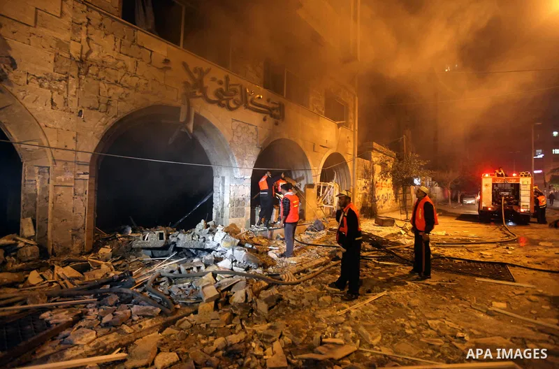 Palestinian firefighters try to extinguish a blaze after an Israeli air strike on the Islamic National Bank building in Gaza City on November 20, 2012. Israeli leaders discussed an Egyptian plan for a truce with Gaza's r...