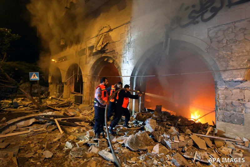 Palestinian firefighters try to extinguish a blaze after an Israeli air strike on the Islamic National Bank building in Gaza City on November 20, 2012. Israeli leaders discussed an Egyptian plan for a truce with Gaza's r...