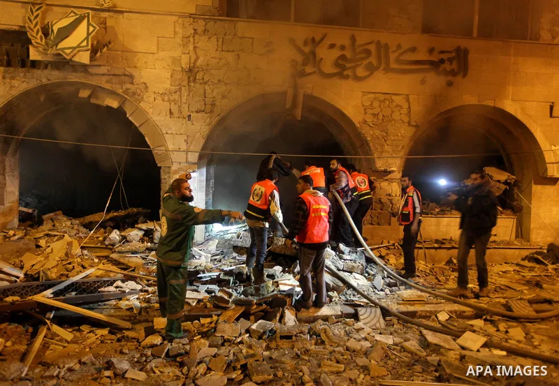 Palestinian firefighters try to extinguish a blaze after an Israeli air strike on the Islamic National Bank building in Gaza City on November 20, 2012. Israeli leaders discussed an Egyptian plan for a truce with Gaza's r...