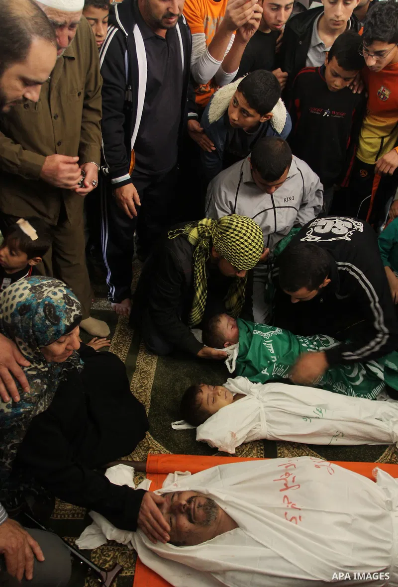 Palestinian mourners gather around the bodies of Foud Hijazi, 45, and his sons Suhaib, 2, and Mohammed, 4, killed in an Israeli strike, during their funeral at a mosque in the Jebaliya refugee camp, in Gaza Strip, Tuesda...