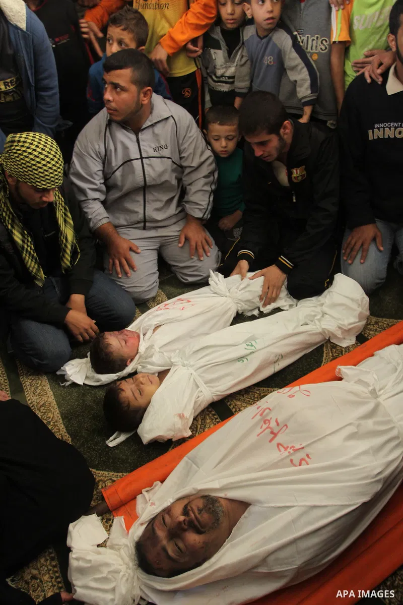 Palestinian mourners gather around the bodies of Foud Hijazi, 45, and his sons Suhaib, 2, and Mohammed, 4, killed in an Israeli strike, during their funeral at a mosque in the Jebaliya refugee camp, in Gaza Strip, Tuesda...