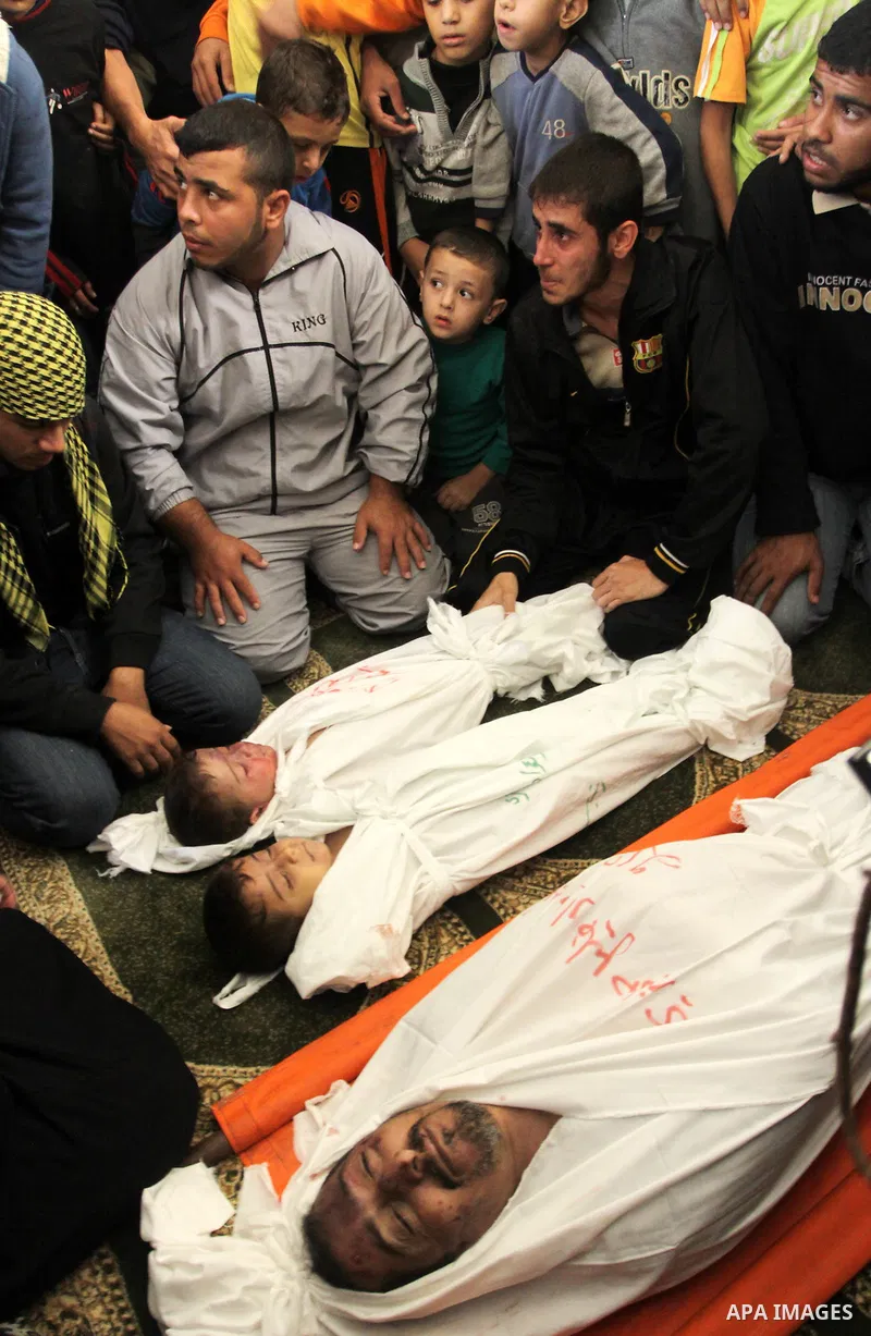 Palestinian mourners gather around the bodies of Foud Hijazi, 45, and his sons Suhaib, 2, and Mohammed, 4, killed in an Israeli strike, during their funeral at a mosque in the Jebaliya refugee camp, in Gaza Strip, Tuesda...