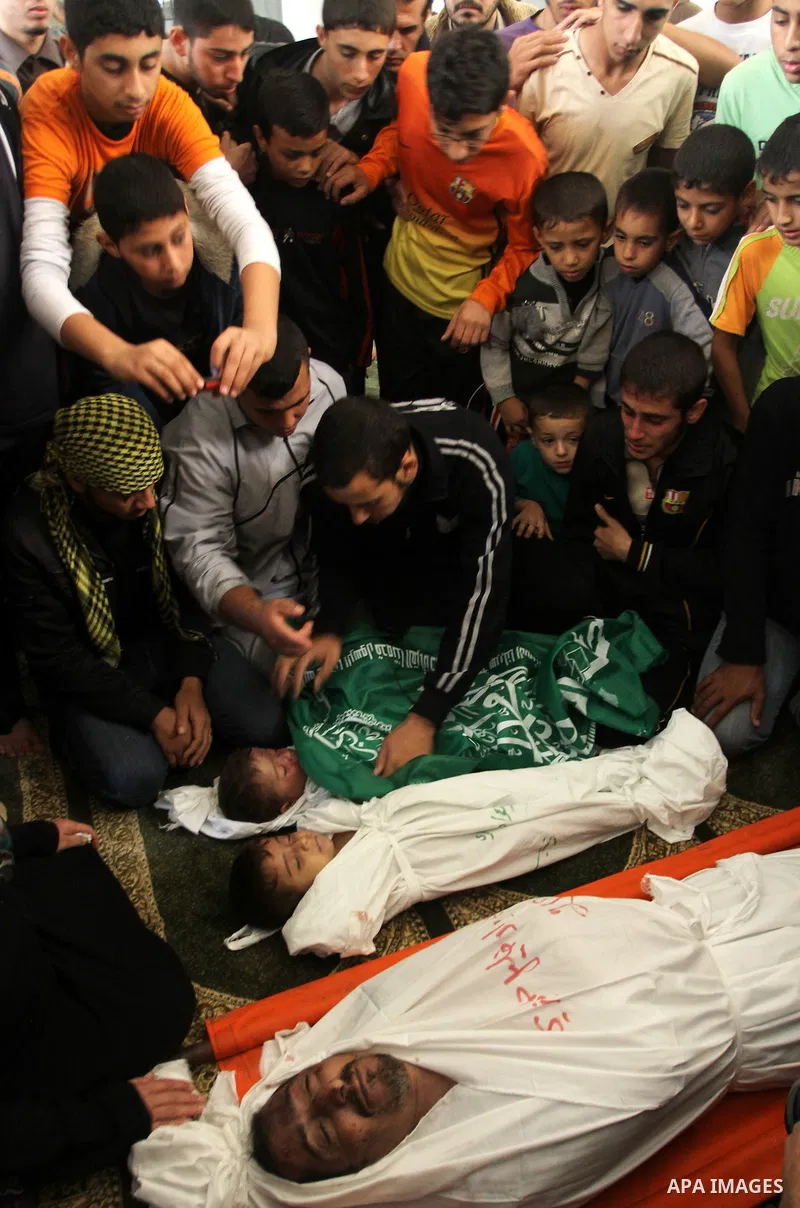 Palestinian mourners gather around the bodies of Foud Hijazi, 45, and his sons Suhaib, 2, and Mohammed, 4, killed in an Israeli strike, during their funeral at a mosque in the Jebaliya refugee camp, in Gaza Strip, Tuesda...