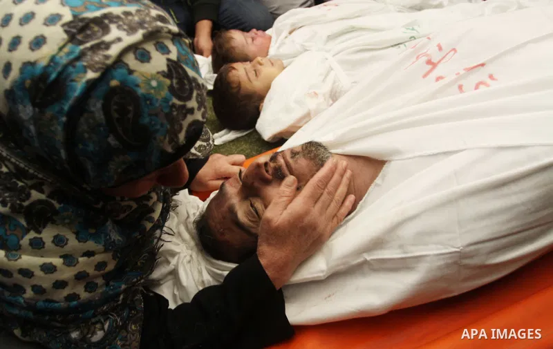 The mother of Foud Hijazi, 45, grieves over the bodies of her son and grandsons Suhaib, 2, and Mohammed, 4, killed in an Israeli strike, during their funeral at a mosque in the Jebaliya refugee camp, in Gaza Strip, Tuesd...