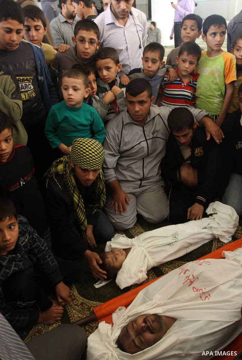 Palestinian mourners gather around the bodies of Foud Hijazi, 45, and his sons Suhaib, 2, and Mohammed, 4, killed in an Israeli strike, during their funeral at a mosque in the Jebaliya refugee camp, in Gaza Strip, Tuesda...