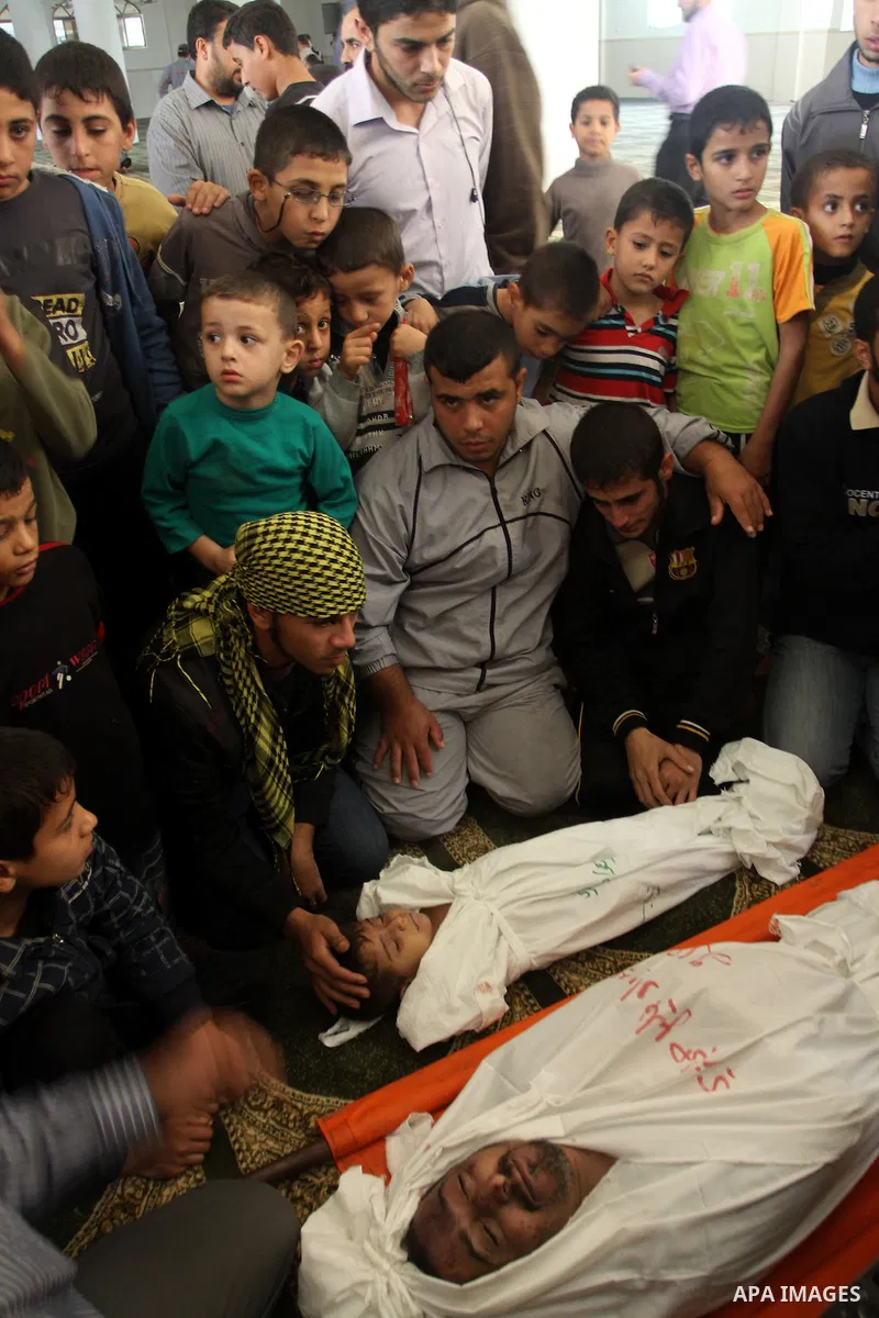 Palestinian mourners gather around the bodies of Foud Hijazi, 45, and his sons Suhaib, 2, and Mohammed, 4, killed in an Israeli strike, during their funeral at a mosque in the Jebaliya refugee camp, in Gaza Strip, Tuesda...