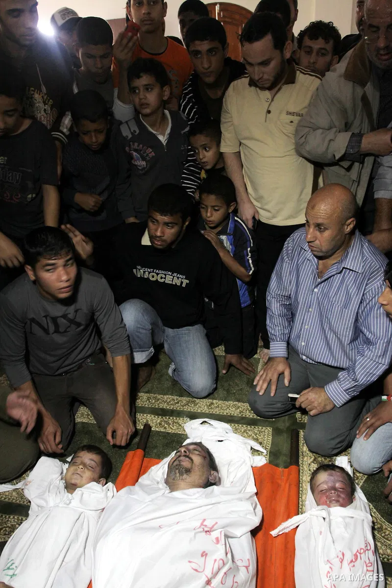 Palestinian mourners gather around the bodies of Foud Hijazi, 45, and his sons Suhaib, 2, and Mohammed, 4, killed in an Israeli strike, during their funeral at a mosque in the Jebaliya refugee camp, in Gaza Strip, Tuesda...