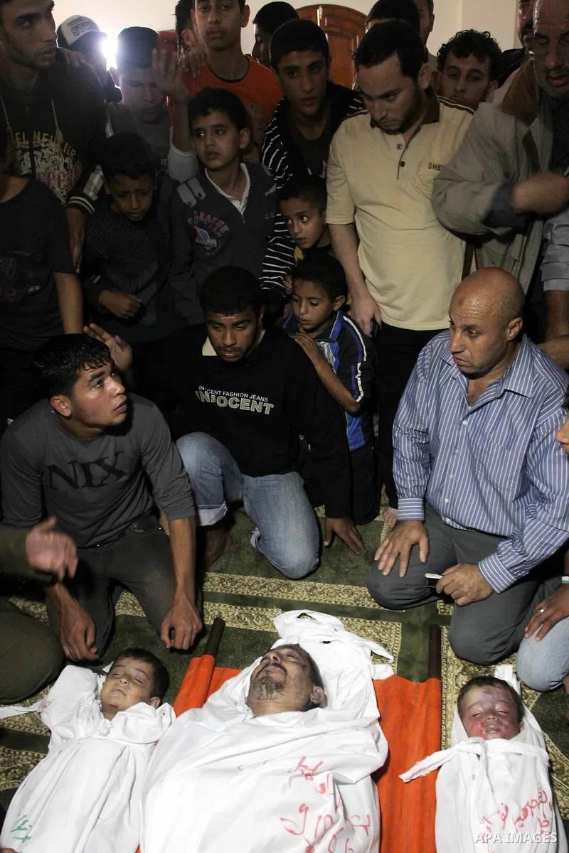 Palestinian mourners gather around the bodies of Foud Hijazi, 45, and his sons Suhaib, 2, and Mohammed, 4, killed in an Israeli strike, during their funeral at a mosque in the Jebaliya refugee camp, in Gaza Strip, Tuesda...