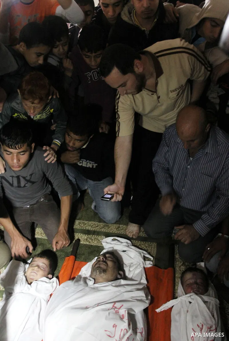 Palestinian mourners gather around the bodies of Foud Hijazi, 45, and his sons Suhaib, 2, and Mohammed, 4, killed in an Israeli strike, during their funeral at a mosque in the Jebaliya refugee camp, in Gaza Strip, Tuesda...