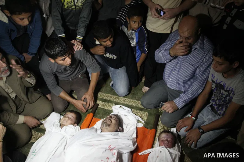 Palestinian mourners gather around the bodies of Foud Hijazi, 45, and his sons Suhaib, 2, and Mohammed, 4, killed in an Israeli strike, during their funeral at a mosque in the Jebaliya refugee camp, in Gaza Strip, Tuesda...