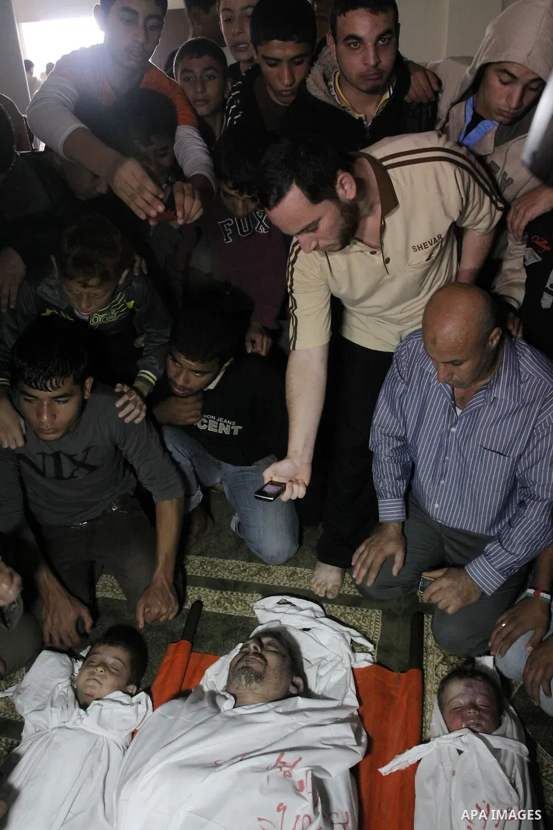 Palestinian mourners gather around the bodies of Foud Hijazi, 45, and his sons Suhaib, 2, and Mohammed, 4, killed in an Israeli strike, during their funeral at a mosque in the Jebaliya refugee camp, in Gaza Strip, Tuesda...