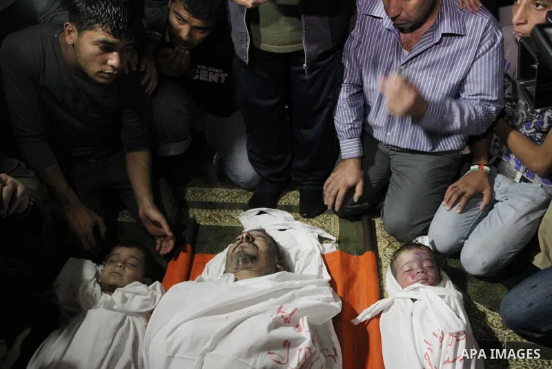 Palestinian mourners gather around the bodies of Foud Hijazi, 45, and his sons Suhaib, 2, and Mohammed, 4, killed in an Israeli strike, during their funeral at a mosque in the Jebaliya refugee camp, in Gaza Strip, Tuesda...
