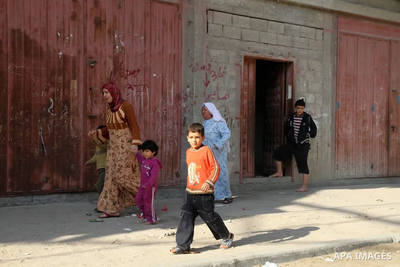 Palestinians get out of their houses after Israeli aircraft threatened to target the area, in the Jebaliya refugee camp, in Gaza Strip, Tuesday, Nov. 20, 2012. Palestinian families are fleeing their homes destroyed by ai...
