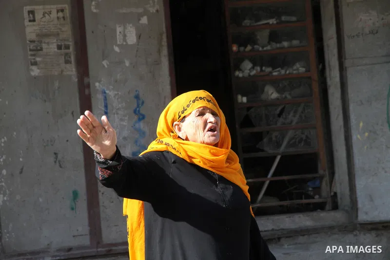 A Palestinian woman gets out of her house after Israeli aircraft threatened to target the area, in the Jebaliya refugee camp, in Gaza Strip, Tuesday, Nov. 20, 2012. Palestinian families are fleeing their homes destroyed...