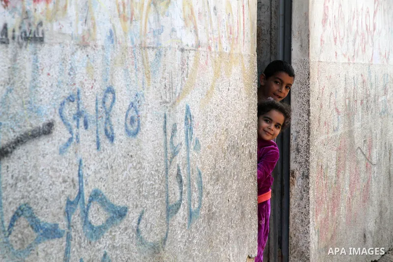 Palestinian children prepare to get out of their houses after Israeli aircraft threatened to target the area, in the Jebaliya refugee camp, in Gaza Strip, Tuesday, Nov. 20, 2012. Palestinian families are fleeing their ho...