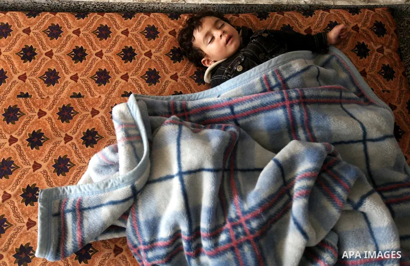 A Displaced Palestinian baby boy from al-Atatra area, whose feld their house, sleeps in a classroom, his temporary residence, at a United Nations-run school in Gaza City, on November 20, 2012. Israeli leaders discussed a...