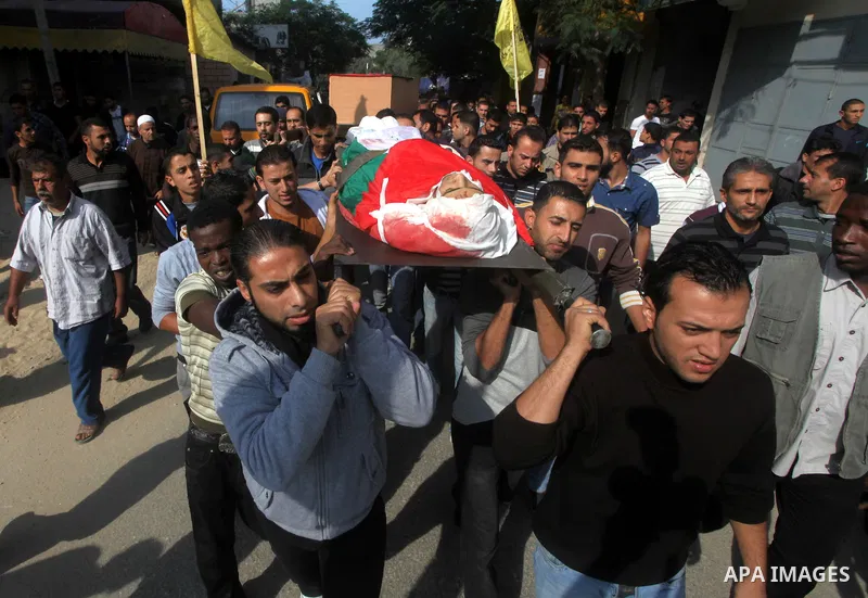 Palestinians carry the body of Osama Shehada, 17, during his funeral in the Nuseirat Refugee Camp, central Gaza Strip, Tuesday, Nov. 20, 2012. Shehada was killed in an Israeli air strike on Monday while walking with his...