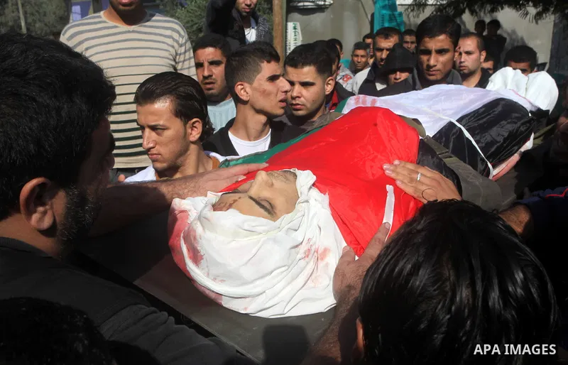 Palestinians carry the body of Osama Shehada, 17, during his funeral in the Nuseirat Refugee Camp, central Gaza Strip, Tuesday, Nov. 20, 2012. Shehada was killed in an Israeli air strike on Monday while walking with his...