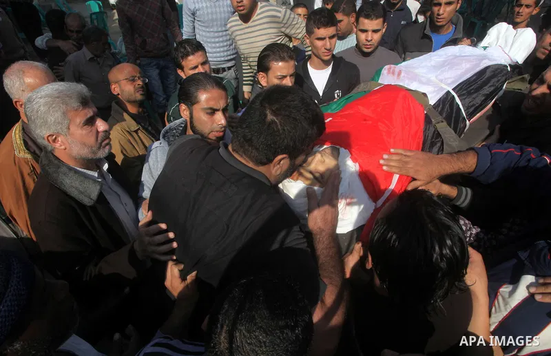 Palestinians carry the body of Osama Shehada, 17, during his funeral in the Nuseirat Refugee Camp, central Gaza Strip, Tuesday, Nov. 20, 2012. Shehada was killed in an Israeli air strike on Monday while walking with his...