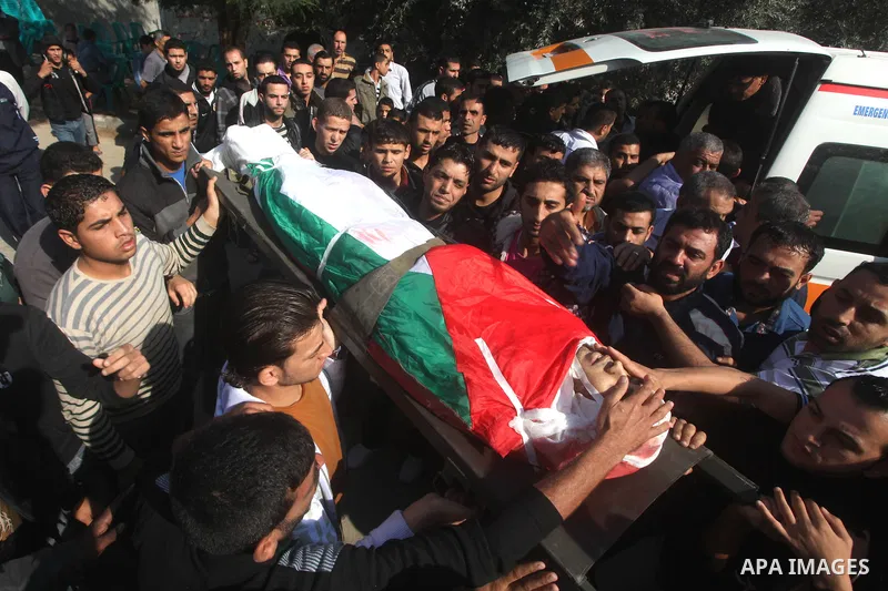 Palestinians carry the body of Osama Shehada, 17, during his funeral in the Nuseirat Refugee Camp, central Gaza Strip, Tuesday, Nov. 20, 2012. Shehada was killed in an Israeli air strike on Monday while walking with his...