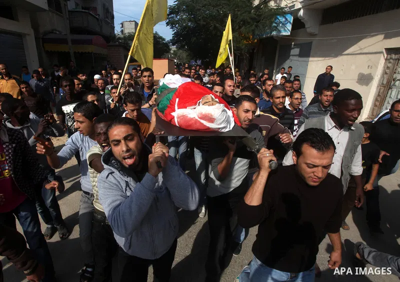 Palestinians carry the body of Osama Shehada, 17, during his funeral in the Nuseirat Refugee Camp, central Gaza Strip, Tuesday, Nov. 20, 2012. Shehada was killed in an Israeli air strike on Monday while walking with his...