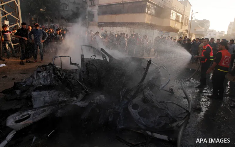 Palestinian firefighters extinguish fire from a vehicle following an Israeli strike in Gaza City on November 20, 2012. Israel's air force dropped leaflets across several districts of Gaza City urging people to evacuate t...