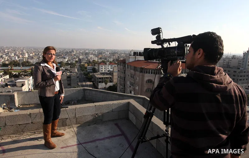 Palestinian members of media record a report on a building in Gaza city, on November 20, 2012. Two Palestinian journalists were killed in an Israeli airstrike on Gaza City Tuesday evening, after media buildings were hit...