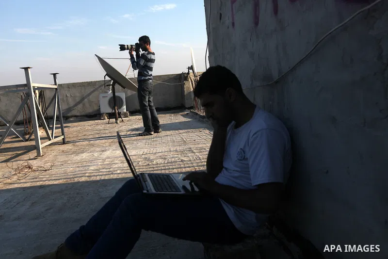 A Palestinian photographer checks his laptop on a building in Gaza city, on November 20, 2012. Two Palestinian journalists were killed in an Israeli airstrike on Gaza City Tuesday evening, after media buildings were hit...
