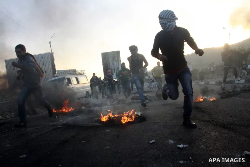 Palestinian stone throwers run for cover during clashes with Israeli security forces in the West Bank city of Nablus, on November 20, 2012. The West Bank has witnessed almost daily demonstrations in support of Gaza Pales...