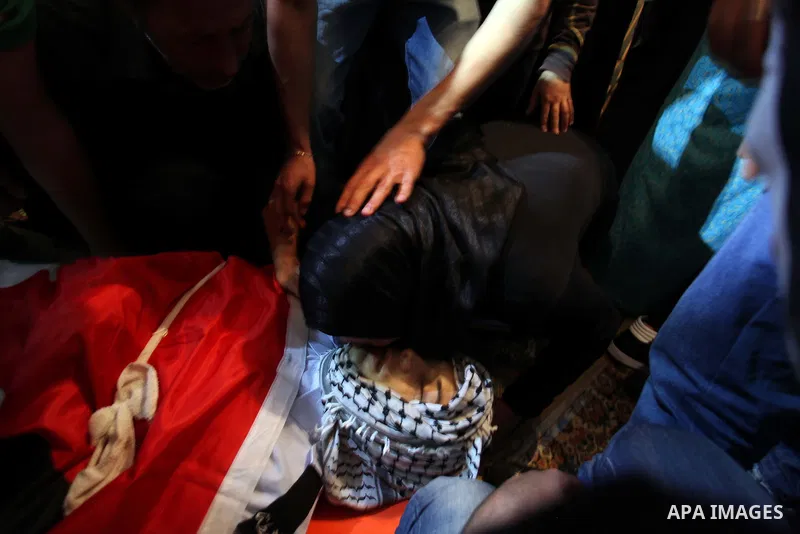 Relatives grieve Rushdi Tamimi who died of injuries sustained during clashes Saturday with Israeli security, during his funeral in the West Bank city of Ramallah, Tuesday, Nov 20, 2012. Tamimi was wounded during a protes...