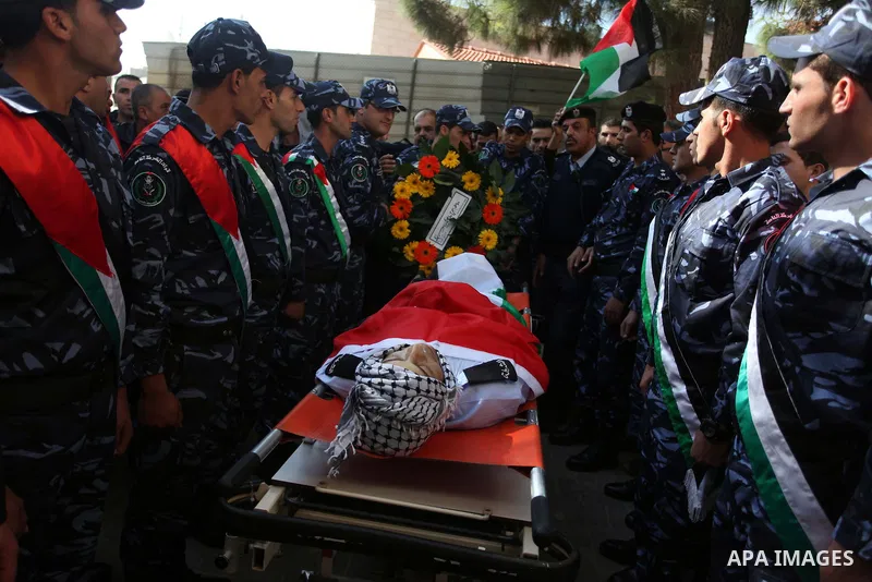 Palestinian policemen carry the body of their comrade Rushdi Tamimi, 31, during his funeral procession in the West Bank city of Ramallah November 20, 2012. amimi was wounded during a protest against Israel's operation in...