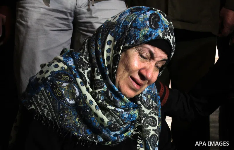 The mother of Foud Hijazi, 45, grieves over the bodies of her son and grandsons Suhaib, 2, and Mohammed, 4, killed in an Israeli strike, during their funeral at a mosque in the Jebaliya refugee camp, in Gaza Strip, Tuesd...