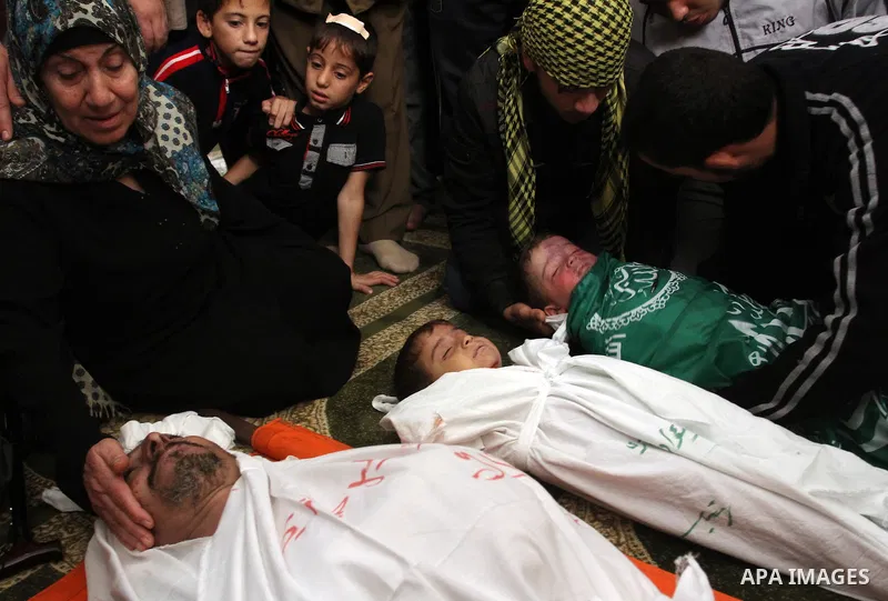 The mother of Foud Hijazi, 45, grieves over the bodies of her son and grandsons Suhaib, 2, and Mohammed, 4, killed in an Israeli strike, during their funeral at a mosque in the Jebaliya refugee camp, in Gaza Strip, Tuesd...