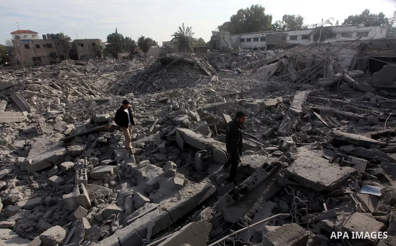 Palestinians look at government offices destroyed in an Israeli airstrike in Gaza City, 21 November 2012. Palestinian militants renewed their rocket fire on Israel 21 November and Israel continued pounding targets in the...