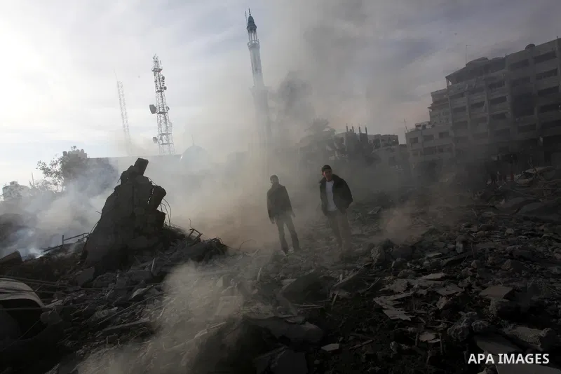 Palestinians look at government offices destroyed in an Israeli airstrike in Gaza City, 21 November 2012. Palestinian militants renewed their rocket fire on Israel 21 November and Israel continued pounding targets in the...