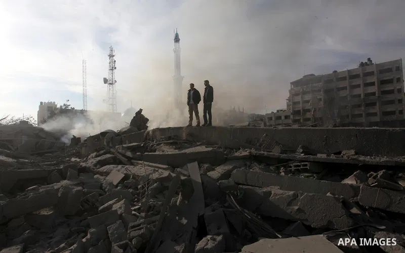 Palestinians look at government offices destroyed in an Israeli airstrike in Gaza City, 21 November 2012. Palestinian militants renewed their rocket fire on Israel 21 November and Israel continued pounding targets in the...