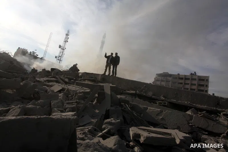 Palestinians look at government offices destroyed in an Israeli airstrike in Gaza City, 21 November 2012. Palestinian militants renewed their rocket fire on Israel 21 November and Israel continued pounding targets in the...