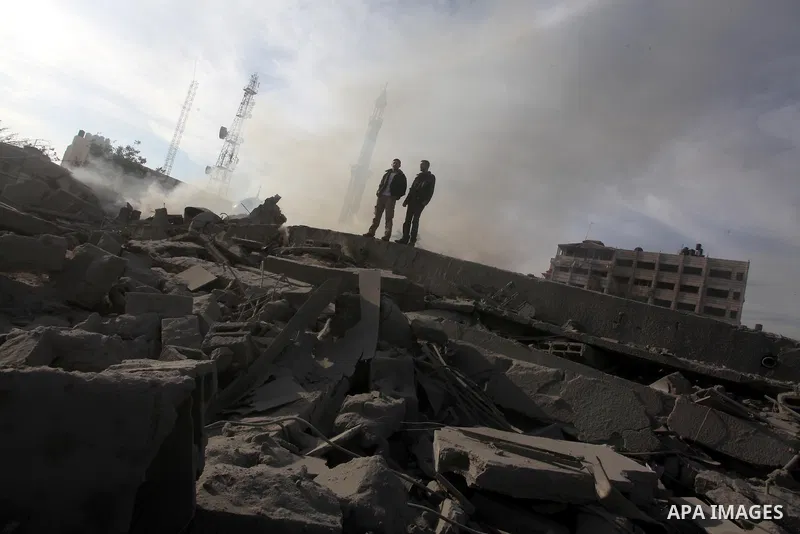 Palestinians look at government offices destroyed in an Israeli airstrike in Gaza City, 21 November 2012. Palestinian militants renewed their rocket fire on Israel 21 November and Israel continued pounding targets in the...