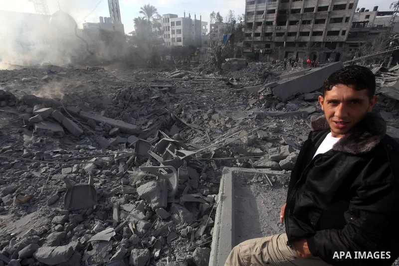 A Palestinian looks at government offices destroyed in an Israeli airstrike in Gaza City, 21 November 2012. Palestinian militants renewed their rocket fire on Israel 21 November and Israel continued pounding targets in t...