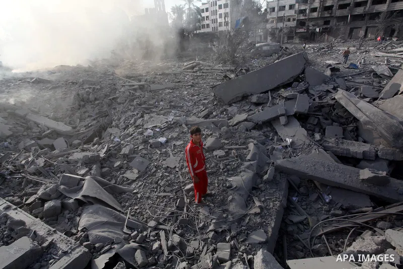 A Palestinian looks at government offices destroyed in an Israeli airstrike in Gaza City, 21 November 2012. Palestinian militants renewed their rocket fire on Israel 21 November and Israel continued pounding targets in t...