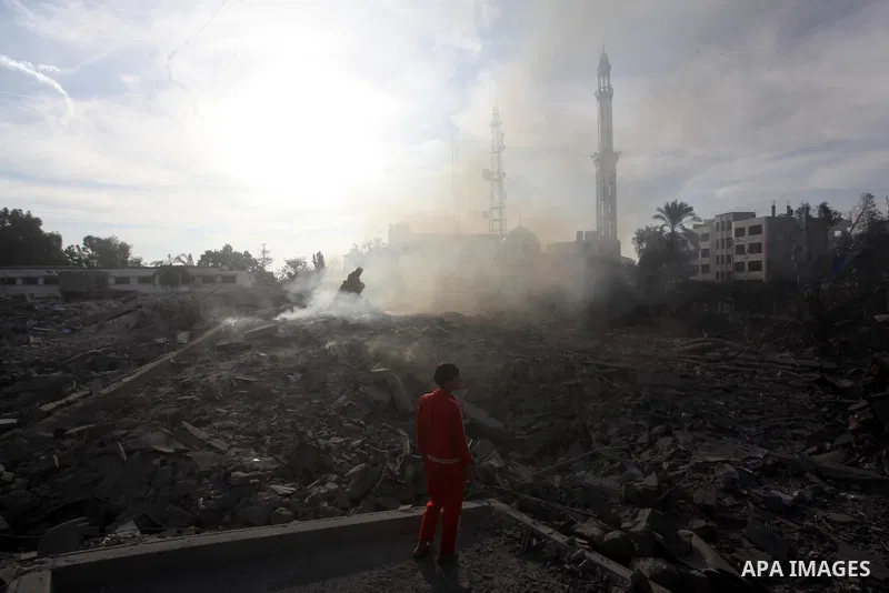A Palestinian looks at government offices destroyed in an Israeli airstrike in Gaza City, 21 November 2012. Palestinian militants renewed their rocket fire on Israel 21 November and Israel continued pounding targets in t...