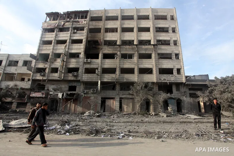 Palestinians look at government offices destroyed in an Israeli airstrike in Gaza City, 21 November 2012. Palestinian militants renewed their rocket fire on Israel 21 November and Israel continued pounding targets in the...