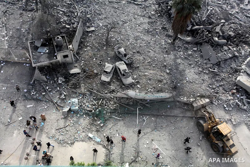 Palestinians look at government offices destroyed in an Israeli airstrike in Gaza City, 21 November 2012. Palestinian militants renewed their rocket fire on Israel 21 November and Israel continued pounding targets in the...
