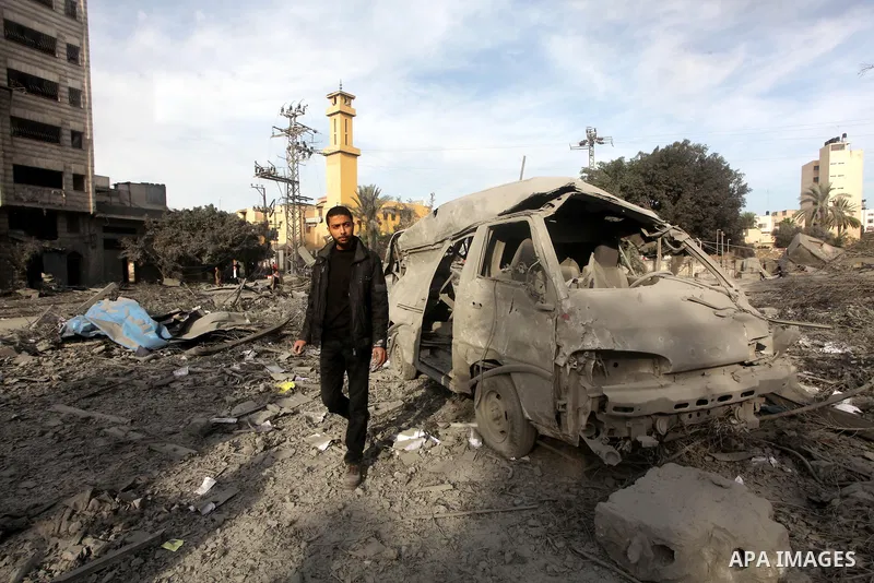 A Palestinian looks at government offices destroyed in an Israeli airstrike in Gaza City, 21 November 2012. Palestinian militants renewed their rocket fire on Israel 21 November and Israel continued pounding targets in t...