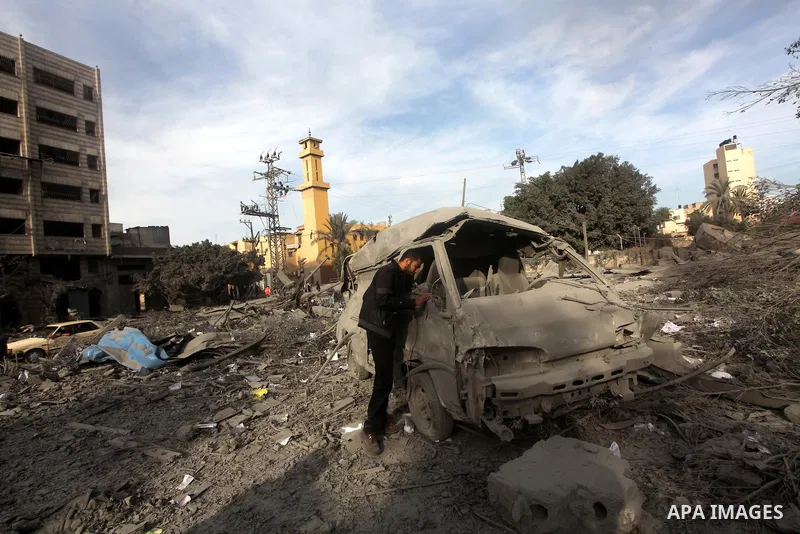 A Palestinian looks at government offices destroyed in an Israeli airstrike in Gaza City, 21 November 2012. Palestinian militants renewed their rocket fire on Israel 21 November and Israel continued pounding targets in t...
